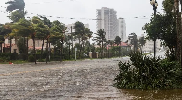 A photo of a flooded suburban street and heavy winds during Hurricane Helene.