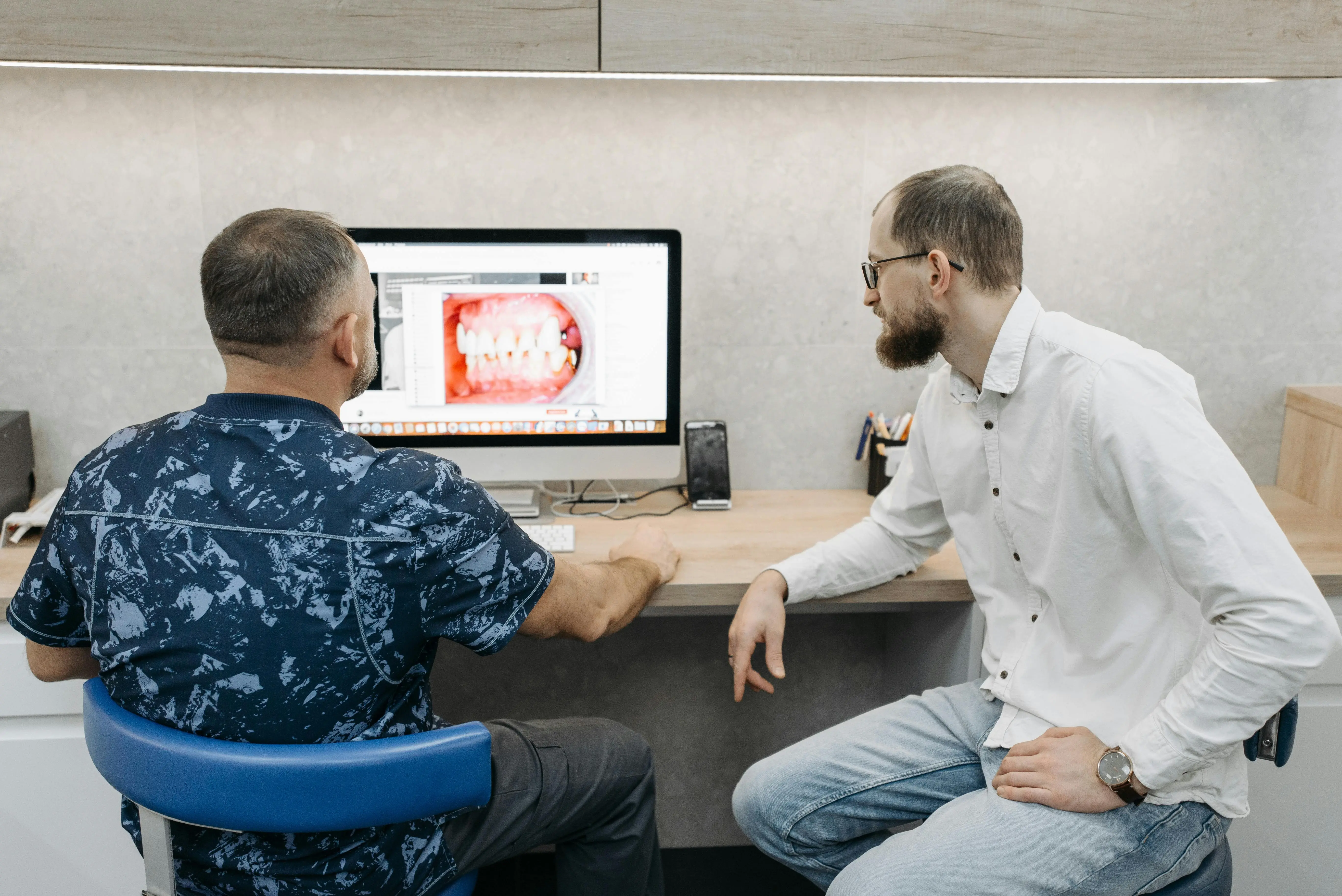 Dentist reviewing computer screen with patient